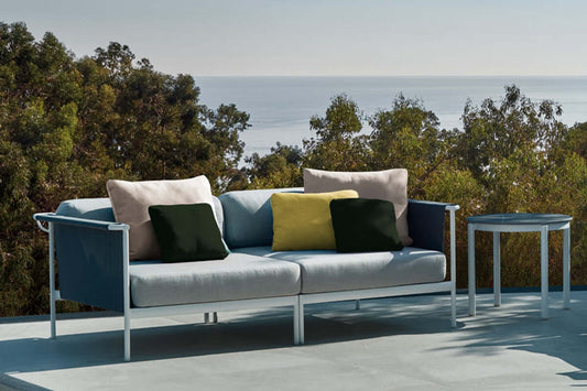 Coussin d'extérieur en mousse sur mesure sur un canapé avec vue sur la mer, montrant confort et style.