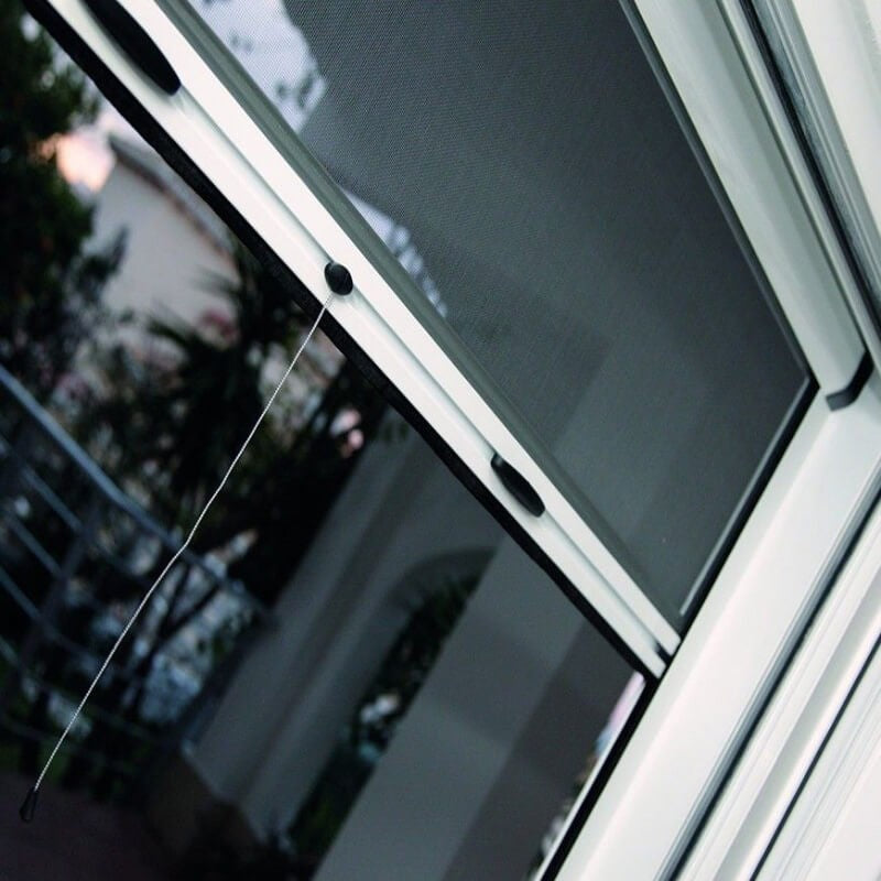 Moustiquaire enroulable Rolly installée sur une fenêtre, offrant protection contre les insectes avec ventilation optimale.