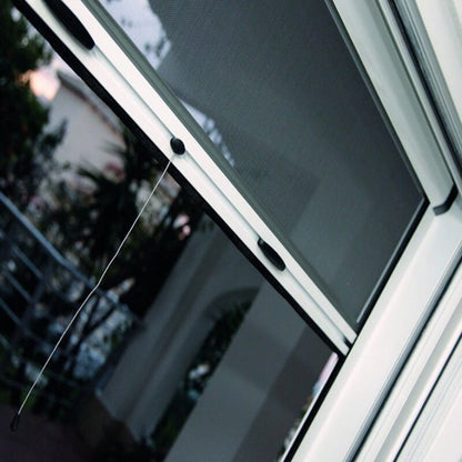 Moustiquaire enroulable Rolly installée sur une fenêtre, offrant protection contre les insectes avec ventilation optimale.