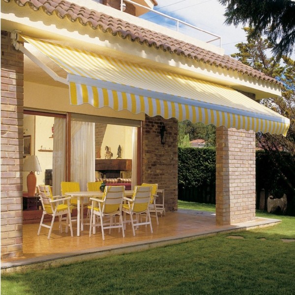Store banne à toile rayée jaune et blanche déployé au-dessus d’une terrasse